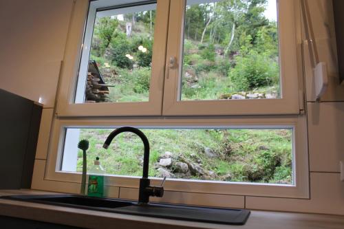 a kitchen sink with a window above a kitchen counter at Ferienhaus Rauhfelsen in Baiersbronn