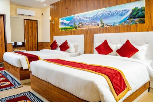 a hotel room with two beds with red pillows at Hotel Palazzo in Kathmandu