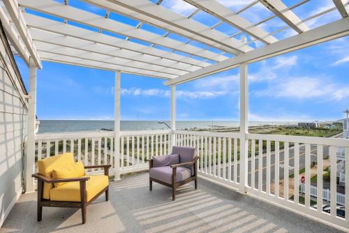 a balcony with chairs and a view of the ocean at Stunning Beachfront Queens Getaway townhouse in Far Rockaway