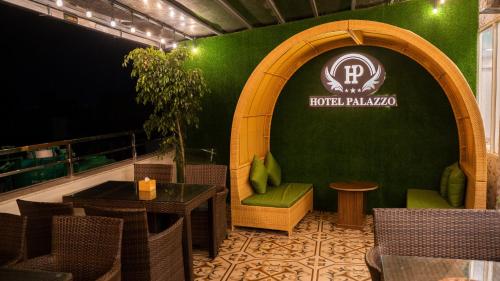 a restaurant with a green wall and a table and chairs at Hotel Palazzo in Kathmandu