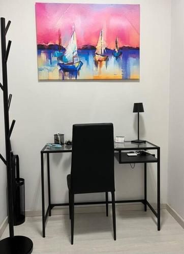een bureau met een stoel en een schilderij aan de muur bij feelgood in Trieste