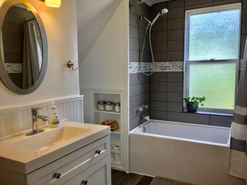 a bathroom with a sink and a tub and a mirror at Parkman Pad in Montague in Montague