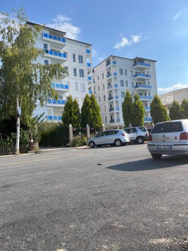 a parking lot with cars parked in front of a building at Tushemisht Lake View Studio Apartment in Pogradec