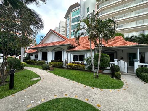 uma casa com uma palmeira ao lado de um edifício em Wannashan pool villa em South Pattaya