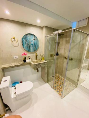 y baño con ducha, aseo y lavamanos. en Espectacular Apartamento Jerusalema Villeta, en Villeta