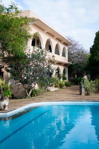 a house with a swimming pool in front of it at Maweni House - Beachfront, Pool, AC & Cook in Kilifi