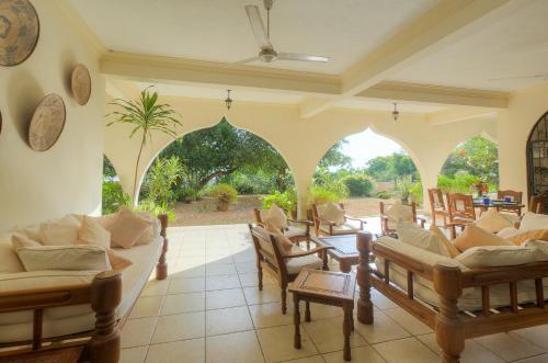 a living room with a lot of chairs and tables at Maweni House - Beachfront, Pool, AC & Cook in Kilifi