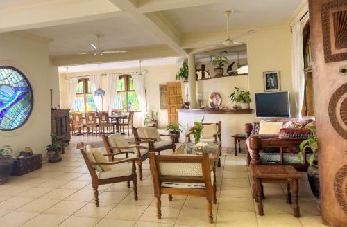 a living room with a lot of chairs and a table at Maweni House - Beachfront, Pool, AC & Cook in Kilifi