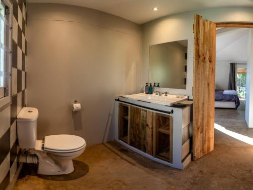 y baño con aseo, lavabo y espejo. en Treebia Self-catering - Loadshedding Free, en Plettenberg Bay