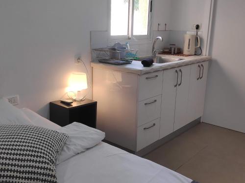 a small kitchen with a bed and a sink at Dead Sea Desert's Edge in Arad