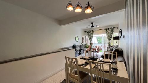 uma sala de jantar e sala de estar com mesa e cadeiras em The Roomah em Bentong