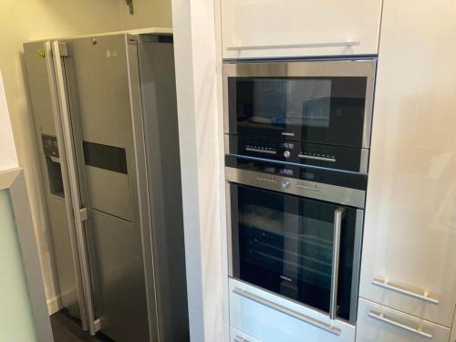 a kitchen with two refrigerators and a microwave at Renntraum über den Dächern von Knittelfeld in Knittelfeld