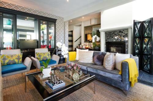 a living room with a couch and a tv at Life & Leisure Boutique Guesthouse in Stellenbosch
