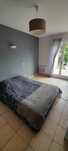 ein Schlafzimmer mit einem Bett und einem großen Fenster in der Unterkunft la pleine sérénité 