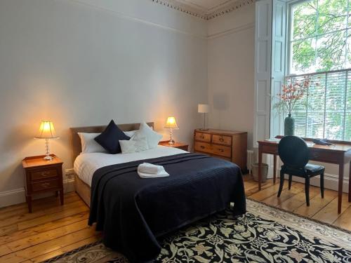 a bedroom with a bed and a desk and a window at Pepper Canister Townhouse in Dublin