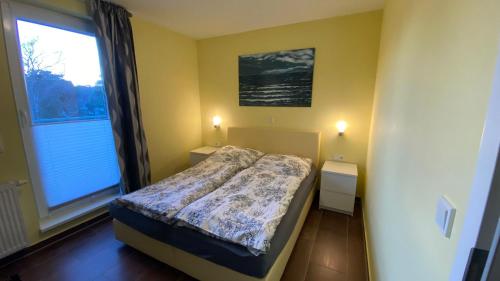 ein Schlafzimmer mit einem Bett und einem großen Fenster in der Unterkunft Haus Am Strand in Breege