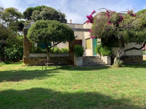 una casa con un banco delante de un patio en Villa Stella, en Anzio