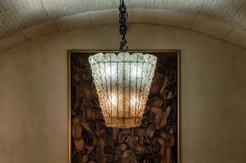 a chandelier hanging from a ceiling with a painting at Suites Lorodellago Como - The House Of Travelers in Como