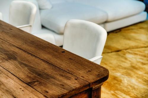 a wooden table with two white chairs and a couch at Suites Lorodellago Como - The House Of Travelers in Como