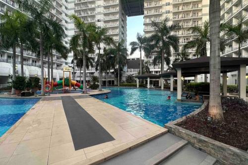 a large swimming pool with a playground in a city at Tropical Pool, Balcony, MOA, Airport, Entire Apartment at Shell Residence in Manila