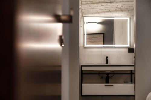 a bathroom with a sink and a mirror at Suites Lorodellago Como - The House Of Travelers in Como