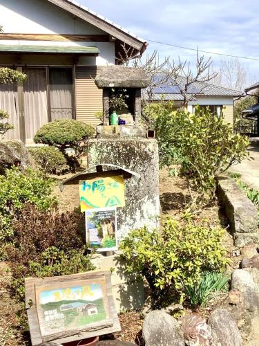 a garden with a sign in front of a house at 体験型農家民泊「お陽さまと風」 in Makiguchi