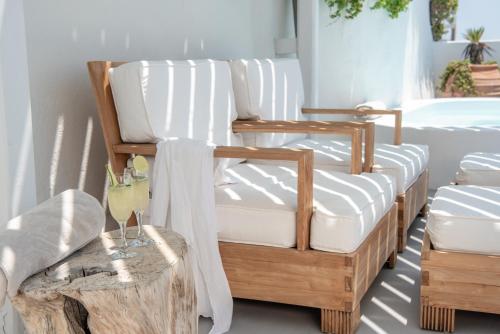 a room with two white chairs and a table at Native Eco Villas in Imerovigli