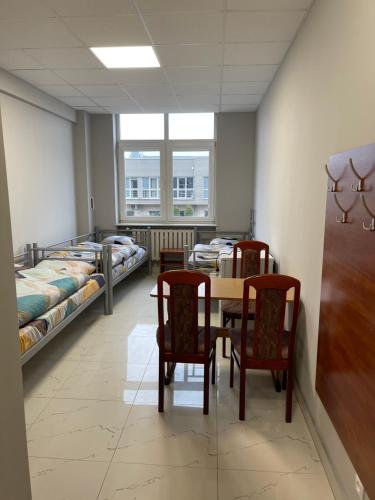 a room with a table and chairs and beds at Hostel ELDORADO in Końskie