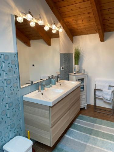 uma casa de banho com um lavatório e um espelho em Charming two bedroom house em Strevi