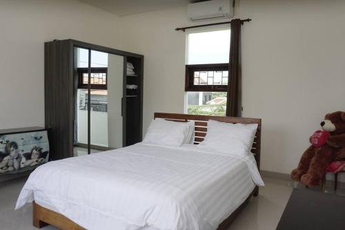 1 dormitorio con cama blanca y osito de peluche en Villa 3-Bedroom with pool, en Canggu