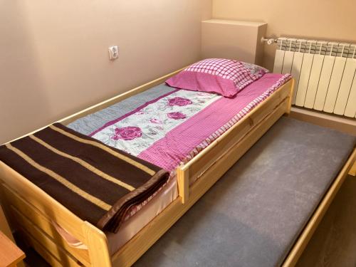 een kleine slaapkamer met een bed met roze lakens bij Dom Młodzieżowy w Polanie in Serednie Małe