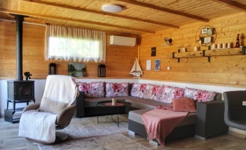 een woonkamer met een bank en een stoel bij Drevenica pri jazere - relax vo vírivke in Banský Studenec