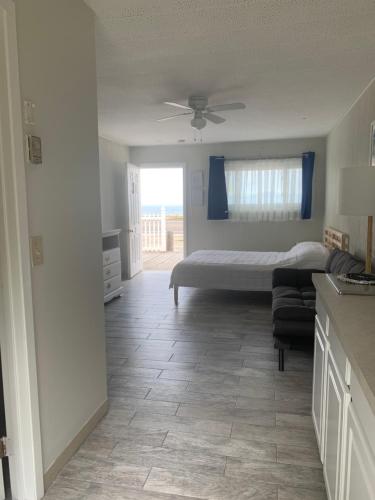 a bedroom with a bed and a kitchen with a window at Southold Beach Motel in Southold