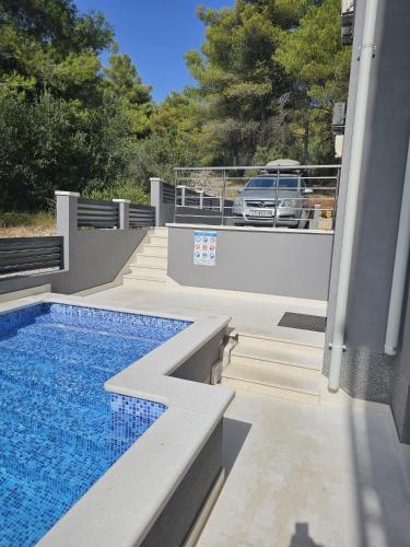 a swimming pool on the side of a house at Villa BOTIĆ in Trogir