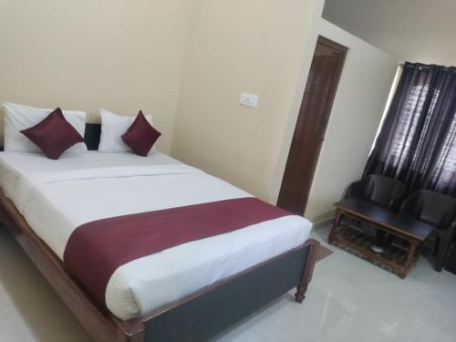 una camera con un grande letto e una sedia di VRS Residency a Mysore