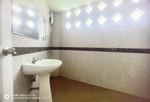 een badkamer met een wastafel en een raam bij YYK Townhouse in Ban Khlong Krang