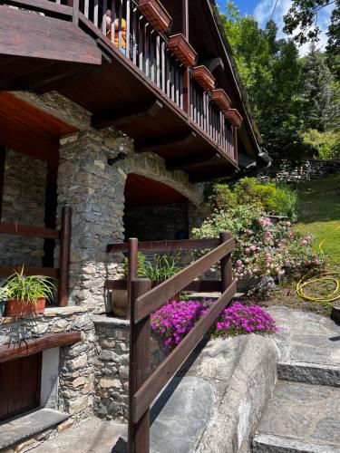 a wooden stairway leading to a house with flowers at Chalet Cheverel (AO) in Remondey