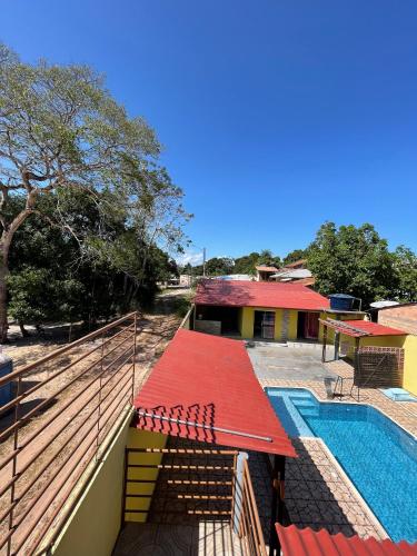 una casa con techo rojo y piscina en Pousada Sossego de Alter en Alter do Chao