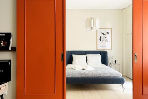 1 dormitorio con 1 cama con puerta de color naranja en Cybele apt downtown, en Volos