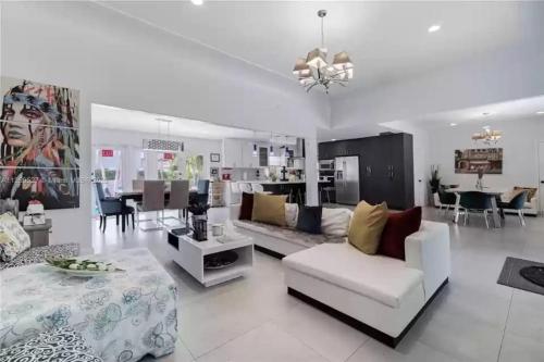a living room with a couch and a dining room at Pool Paradise Half mile to Beach w Massive Yard! in Hollywood