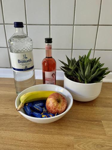 a bowl of fruit and a bottle of water and an apple at ENDLESS: Studio mit Netflix + Workstation im Zentrum in Schwerin