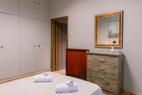 a bedroom with a bed and a mirror and a dresser at Armonia-Art House in Kos