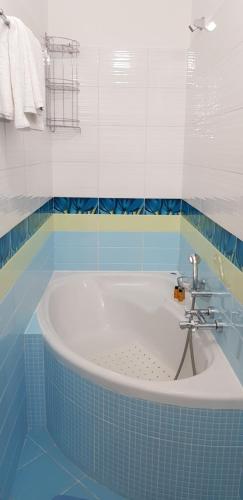 y baño azul y blanco con bañera. en villa strati, en Nauplia