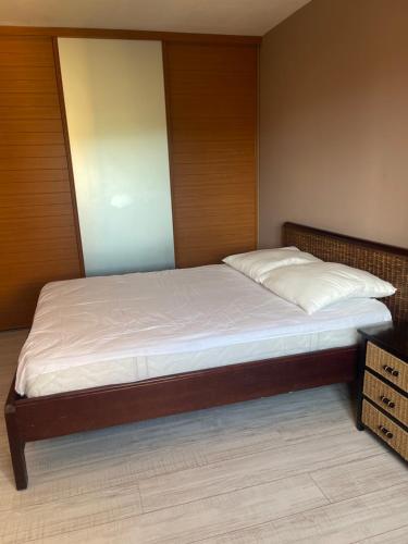 une chambre avec un grand lit avec une tête de lit en bois dans l'établissement le beal, à Hyères