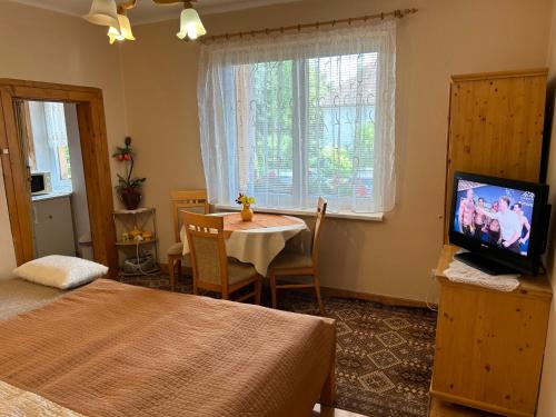 a bedroom with a table and a television in a room at Privát Lenka in Prosiek