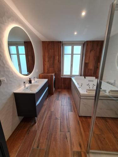 une salle de bain avec deux lavabos, une baignoire et un miroir dans l'établissement 2 pièces, SPA et terrasse, Nancy Thermal, à Nancy