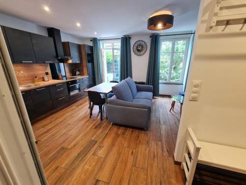 une cuisine et un salon avec un canapé et une table dans l'établissement 2 pièces, SPA et terrasse, Nancy Thermal, à Nancy