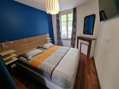 une chambre avec un lit et un mur bleu dans l'établissement 2 pièces, SPA et terrasse, Nancy Thermal, à Nancy