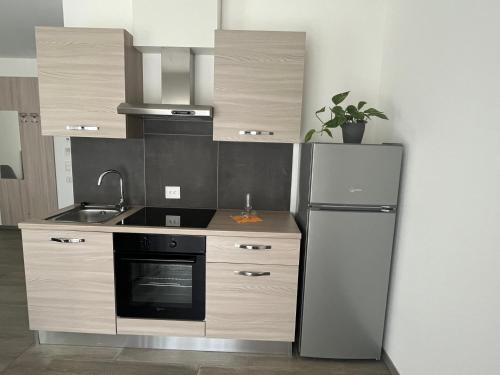 a kitchen with a refrigerator and a sink at Motel Afia in Cama