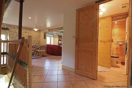 - un couloir avec une porte en bois et une table dans l'établissement La Cage aux Oiseaux, à La Lande-de-Goult